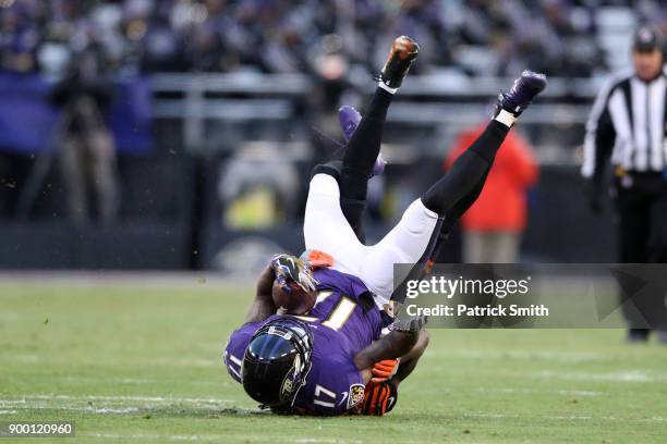 Wide Receiver Mike Wallace of the Baltimore Ravens runs with the ball as he is tackled by cornerback Dre Kirkpatrick of the Cincinnati Bengals in the...