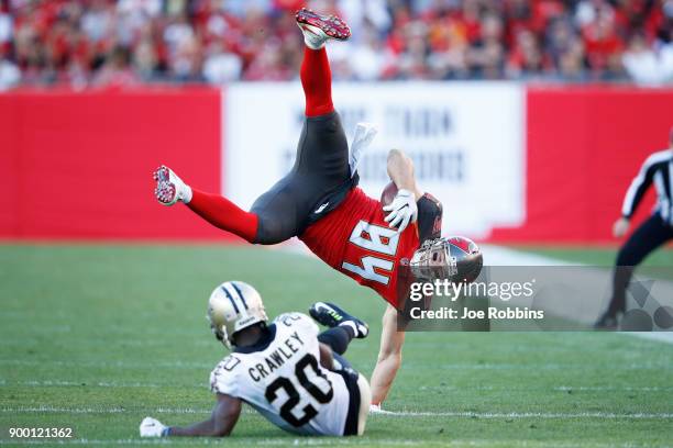 Ken Crawley of the New Orleans Saints trips up Cameron Brate of the Tampa Bay Buccaneers after a catch in the first quarter of a game at Raymond...