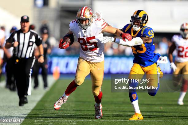 George Kittle of the San Francisco 49ers eludes John Johnson of the Los Angeles Rams on a pass play during the first half of a game at Los Angeles...