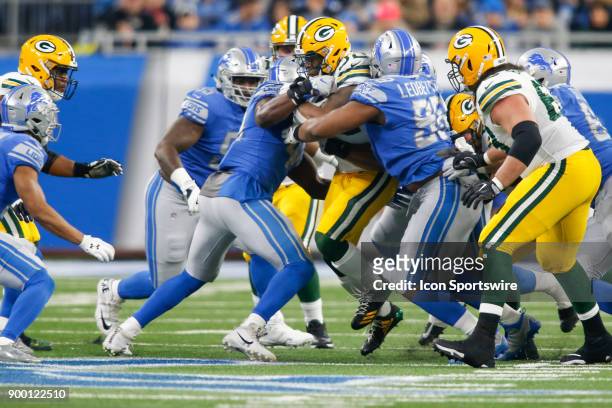 Green Bay Packers running back Devante Mays runs with the ball while being tackled by Detroit Lions defensive tackle Jeremiah Ledbetter and the...