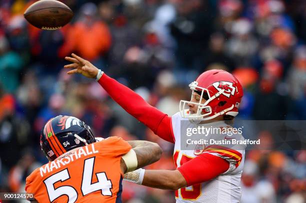 Quarterback Patrick Mahomes of the Kansas City Chiefs passes under pressure by inside linebacker Brandon Marshall of the Denver Broncos int he second...