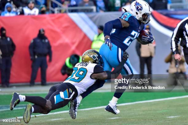Running back Derrick Henry of the Tennessee Titans rushes against safety Tashaun Gipson of the Jacksonville Jaguars at Nissan Stadium on December 31,...
