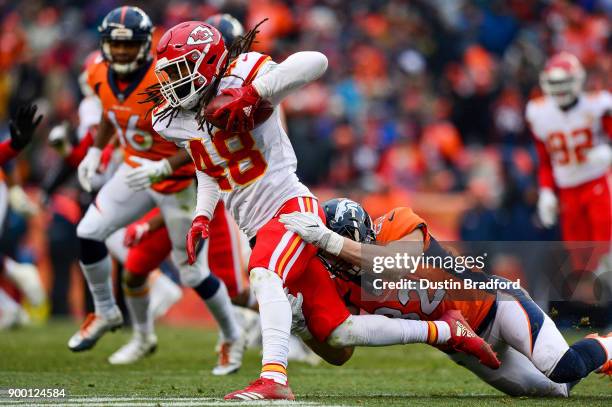 Inside linebacker Terrance Smith of the Kansas City Chiefs is tackled by tight end Jeff Heuerman of the Denver Broncos after a second quarter...