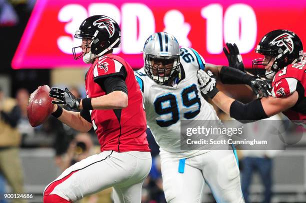 Matt Ryan of the Atlanta Falcons is pressures by Kawann Short of the Carolina Panthers during the first half at Mercedes-Benz Stadium on December 31,...