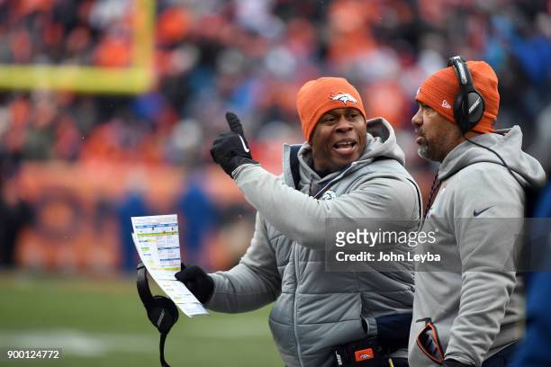 Denver Broncos head coach Vance Joseph screams as running backs coach Eric Studesville listens in during the first quarter on December 31, 2017 in...