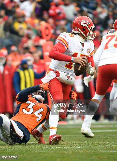 Kansas City Chiefs quarterback Patrick Mahomes escapes the grasp of Denver Broncos defensive back Will Parks and makes a throw down field during the...