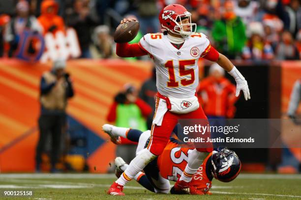 Quarterback Patrick Mahomes of the Kansas City Chiefs throws a pass for a first down after eluding defensive back Will Parks of the Denver Broncos...