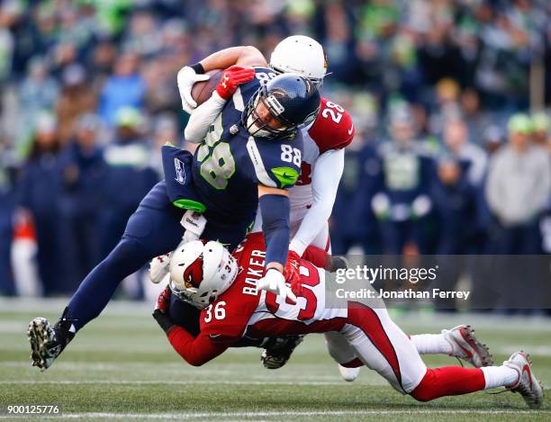 Tight end Jimmy Graham of the Seattle Seahawks makes a 20 yard reception on 4th down against safety Budda Baker of the Arizona Cardinals and Justin...