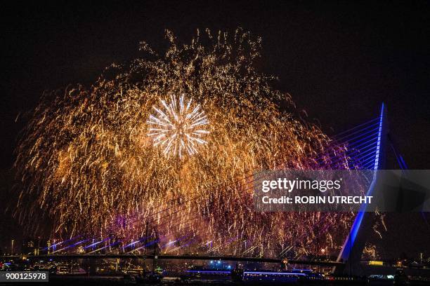 Firework explode at the Erasmusbrug as part of New Year's celebrations in Rotterdam, the Netherlands on January 1, 2018. / AFP PHOTO / Robin UTRECHT...