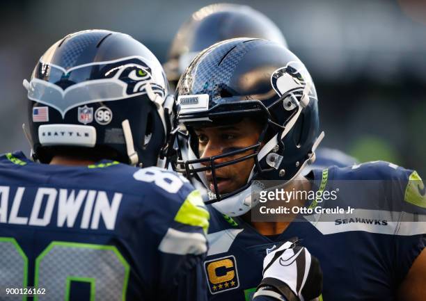 Quarterback Russell Wilson of the Seattle Seahawks greets Doug Baldwin after Baldwin brought in an 18 yard touchdown against the Arizona Cardinals in...