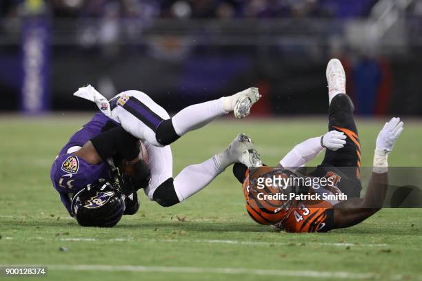 Running Back Javorius Allen of the Baltimore Ravens carries the ball as he is tackled by free safety George Iloka of the Cincinnati Bengals in the...