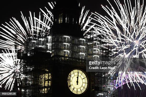 Fireworks explode over Big Ben at midnight as thousands gather to ring in the near year on January 1, 2018 in London, England. Crowds lined the banks...
