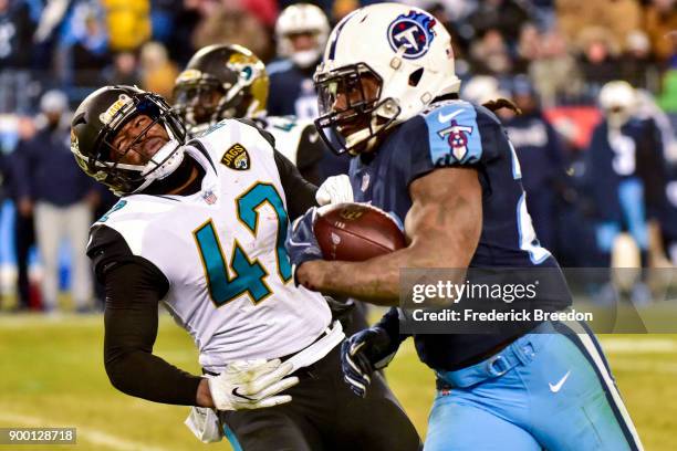 Running back Derrick Henry of the Tennessee Titans carries the ball against safety Barry Church of the Jacksonville Jaguars at Nissan Stadium on...