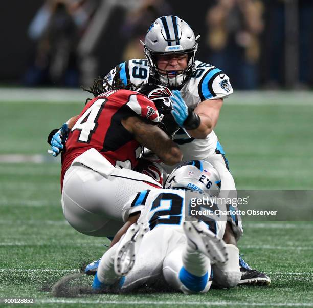 Carolina Panthers middle linebacker Luke Kuechly combines with cornerback Daryl Worley to stop Atlanta Falcons running back Devonta Freeman during...