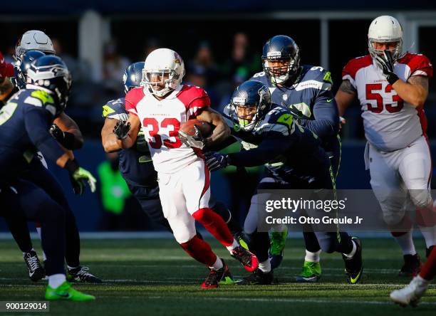Running back Kerwynn Williams of the Arizona Cardinals rushes past defensive end Dwight Freeney of the Seattle Seahawks in the first half at...