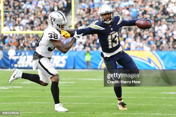 Keenan Allen of the Los Angeles Chargers fends off T.J. Carrie of the Oakland Raiders as Allen makes the catch during the third quarter of the game...