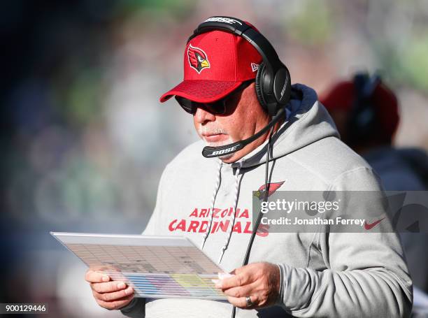 Head coach Bruce Arians of the Arizona Cardinals looks over plays during the game against the Seattle Seahawks at CenturyLink Field on December 31,...