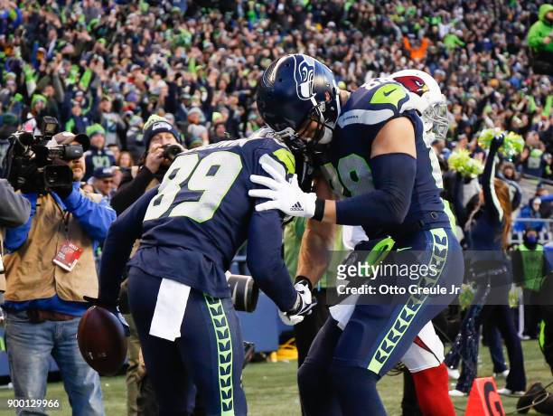 Tight end Jimmy Graham of the Seattle Seahawks greets Doug Baldwin after Baldwin pulled in a 29 yard touchdown against the Arizona Cardinals in the...
