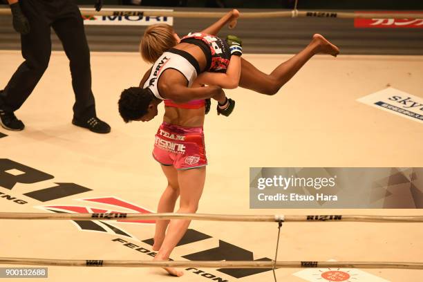 Kanna Asakura of Japan lifts Maria Oliveira Mota of Brazil in the women's super atom weight GP semi-final bout during the RIZIN Fighting World...