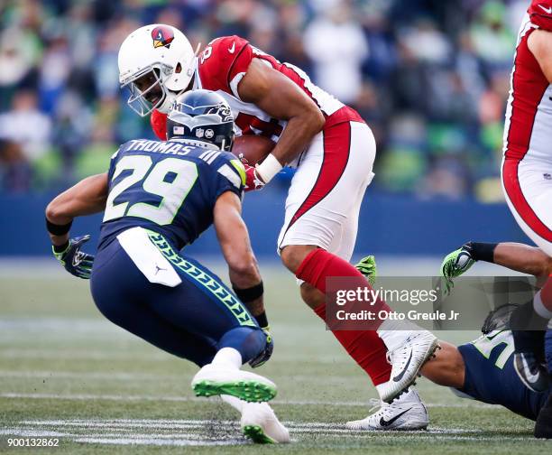 Tight end Jermaine Gresham of the Arizona Cardinals tries to escape free safety Earl Thomas of the Seattle Seahawks during the first half of the game...