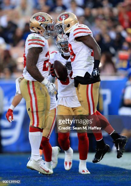 Carlos Hyde and Kendrick Bourne congratulate Aldrick Robinson of the San Francisco 49ers on his touchdown during the second half of a game against...