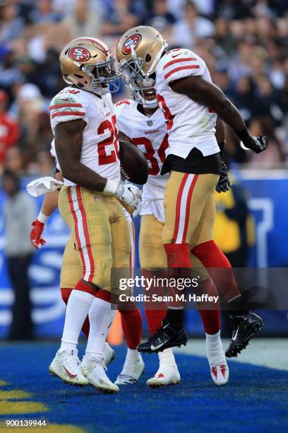 Carlos Hyde and Kendrick Bourne congratulate Aldrick Robinson of the San Francisco 49ers on his touchdown during the second half of a game against...