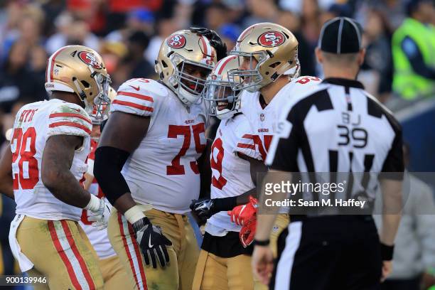 Carlos Hyde and Laken Tomlinson congratulate Aldrick Robinson of the San Francisco 49ers on his touchdown during the second half of a game against...