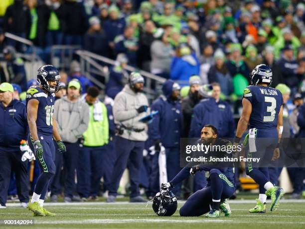 Wide receiver Doug Baldwin of the Seattle Seahawks kneels as he reacts along with Tyler Lockett late in the fourth quarter at CenturyLink Field on...