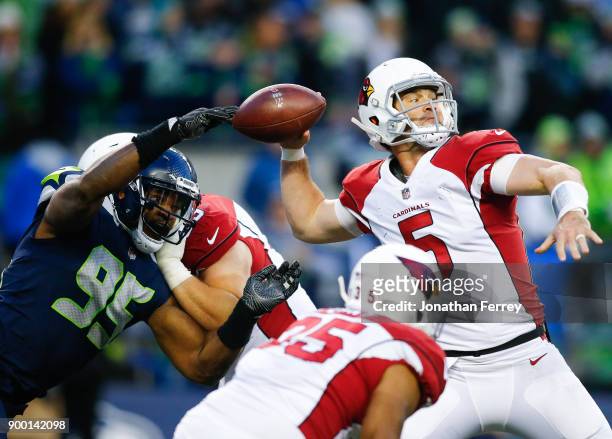 Defensive end Dion Jordan of the Seattle Seahawks nearly tips the ball out of the hands of quarterback Drew Stanton of the Arizona Cardinals in the...