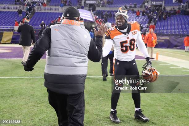 Head coach Marvin Lewis and defensive end Carl Lawson of the Cincinnati Bengals celebrate after a 31-27 win over the Baltimore Ravens at M&T Bank...
