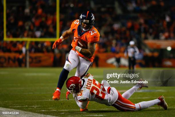 Running back Devontae Booker of the Denver Broncos is tackled by cornerback Kenneth Acker of the Kansas City Chiefs during the fourth quarter at...