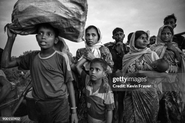 Rohingya Muslim refugees crowd on a berm while waiting to be allowed to proceed after fleeing over the border from Myanmar into Bangladesh at the Naf...