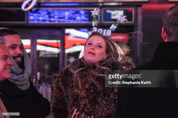 Woman smiles with her friends in Times Square ahead of the New Year's Eve celebration on December 31, 2017 in New York City.