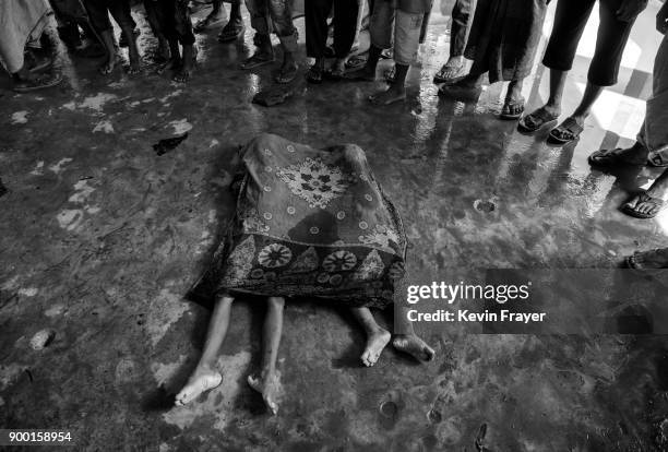 The bodies of two Rohingya refugee children are seen covered prior to burial after a boat capsized killing dozens while fleeing Myanmar on September...