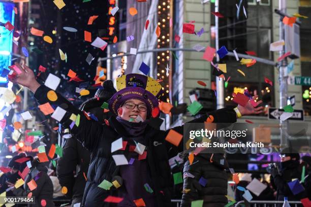 People throw confetti on New Year's Eve in Times Square on January 1, 2018 in New York City.