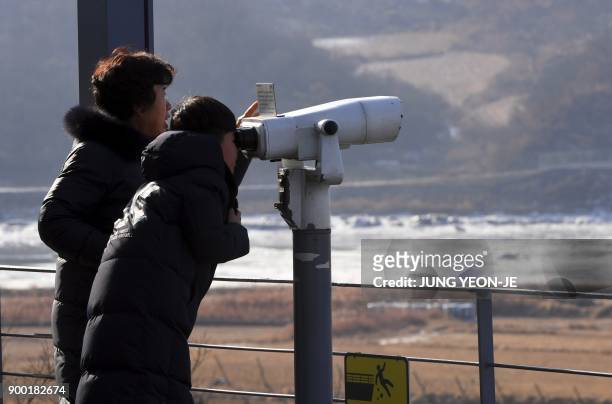 Visitors look through binoculars during a visit to the Imjingak peace park near the Demilitarized Zone dividing the two Koreas in the border city of...