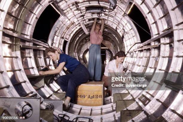 Women workers install fixtures and assemblies to a tail fuselage section of a B-17 bomber at the Douglas Aircraft Company plant, Long Beach, Calif....