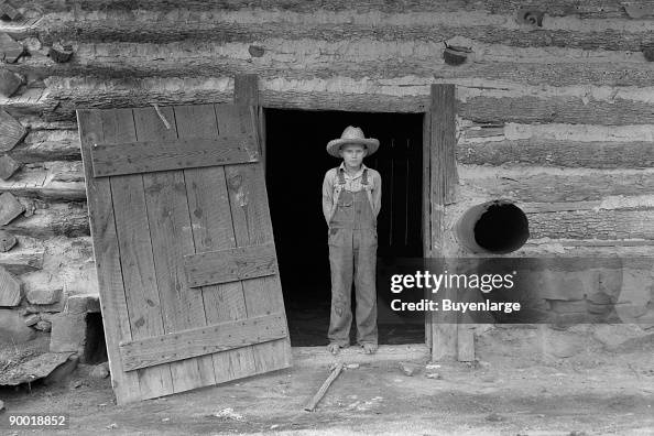 Farm boy in doorway of tobacco barn