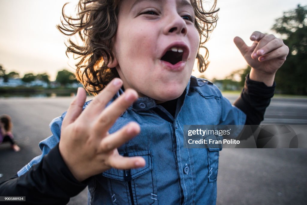 A young boy cheering.