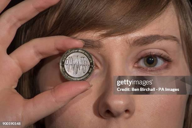 Alex Powell from the Royal Mint, Llantrisant, Wales, holds a &pound;2 coin from the Royal Mint featuring a Frankenstein design commemorating 200...