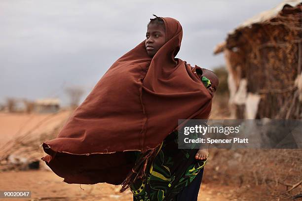 Girl walks home with her younger brother on her back in Dadaab, the world�s biggest refugee complex August 22, 2009 in Dadaab, Kenya. The Dadaab...