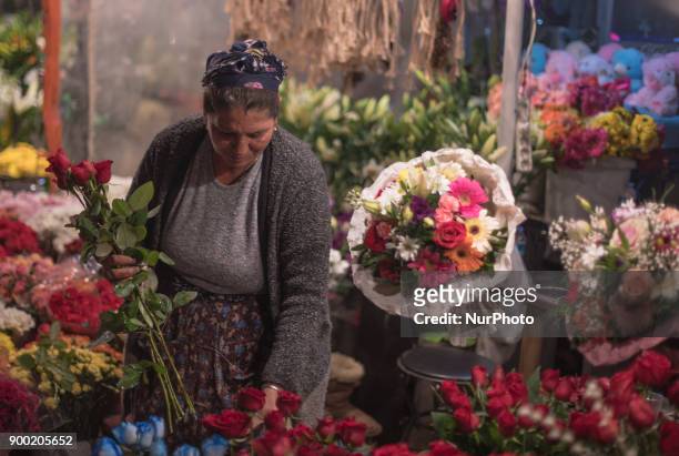 Turkish woman sells flowers to people in Taksim Square in Istanbul on the last night of 2017