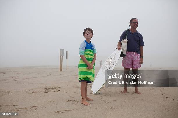 William Earley, age 8 of Chatham, Massachusetts and father Matt Earley watch waves crash on Lighthouse Beach on August 22, 2009 in Chatham,...