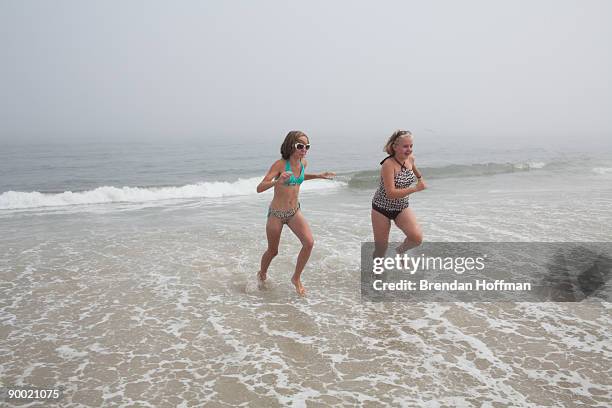 Rachel and Katie of Stafford Springs, Connecticut, run from a large wave on Lighthouse Beach on August 22, 2009 in Chatham, Massachusetts. A strong...