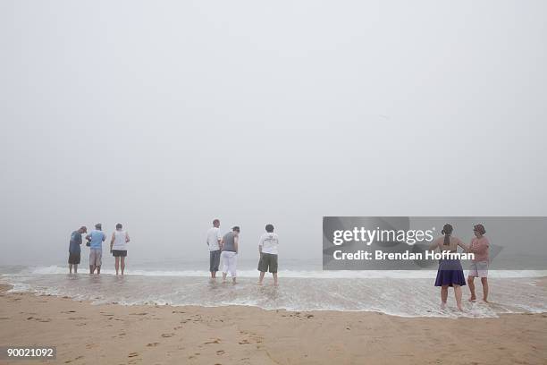 Beachgoers watch large waves crash on Lighthouse Beach, though the ocean is closed to swimming, on August 22, 2009 in Chatham, Massachusetts. A...