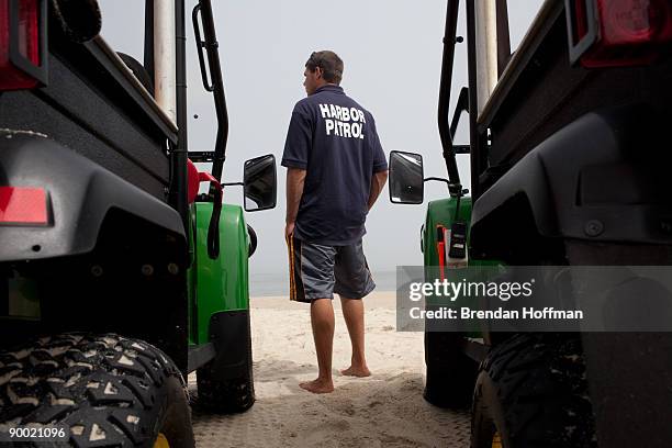 Mike Davis of the Chatham Harbormaster enforces a ban on swimming at Lighthouse Beach on August 22, 2009 in Chatham, Massachusetts. A strong undertow...