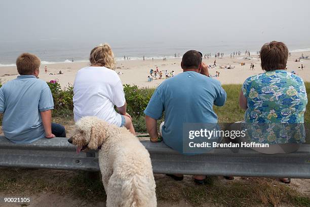 Joey, Emily, Tucker the dog, Joe, and Linda LaCoppola, of Glenville, New York, watch the waves crash on Lighthouse Beach on August 22, 2009 in...