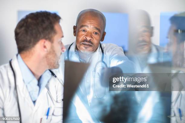 two doctors analysing x-ray image - medical judge stock-fotos und bilder