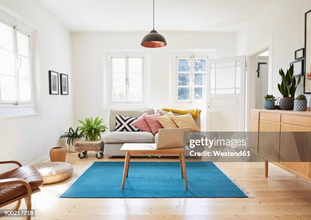 laptop on coffee table in a modern living room of an old country house - huiskamer stockfoto's en -beelden