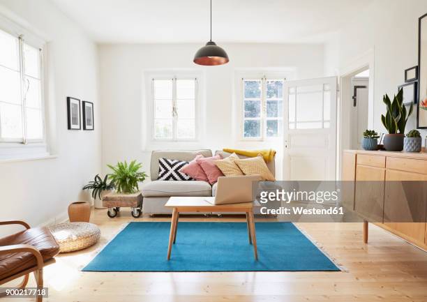 laptop on coffee table in a modern living room of an old country house - living room stock pictures, royalty-free photos & images